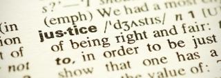 Close-up of the word justice in the dictionary