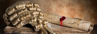 A judge's wig, old scroll, old book, and glasses