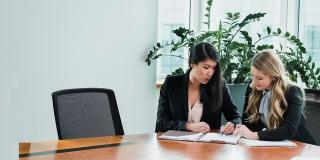 Two students at a conference room desk