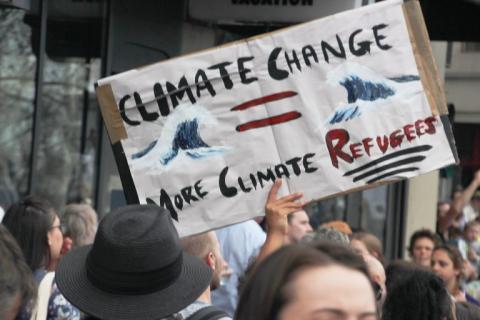 Photo showing banner that reads "climate change = more climate refugees"