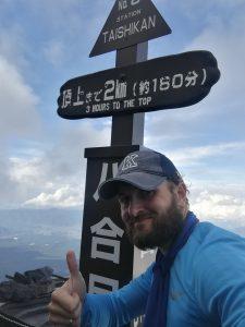 Sokolowski on a mountain, giving a thumbs up