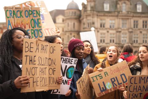 Children hold protest signs during daytime