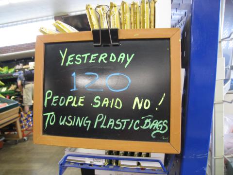 A dry-erase board at a grocery store that reads “YESTERDAY 120 PEOPLE SAID NO! TO USING PLASTIC BAGS”. Photo by Mark Male.