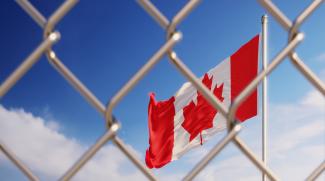 Canadian flag behind fence