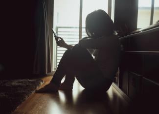 Woman looks at phone in shadow