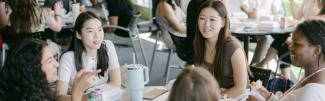 Students around a table having lunch