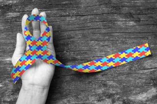A hand holding an equality ribbon
