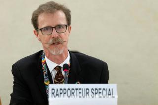 Robert Boyd in front of a placard labeled "Rapporteur special"