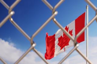 Canadian flag behind fence